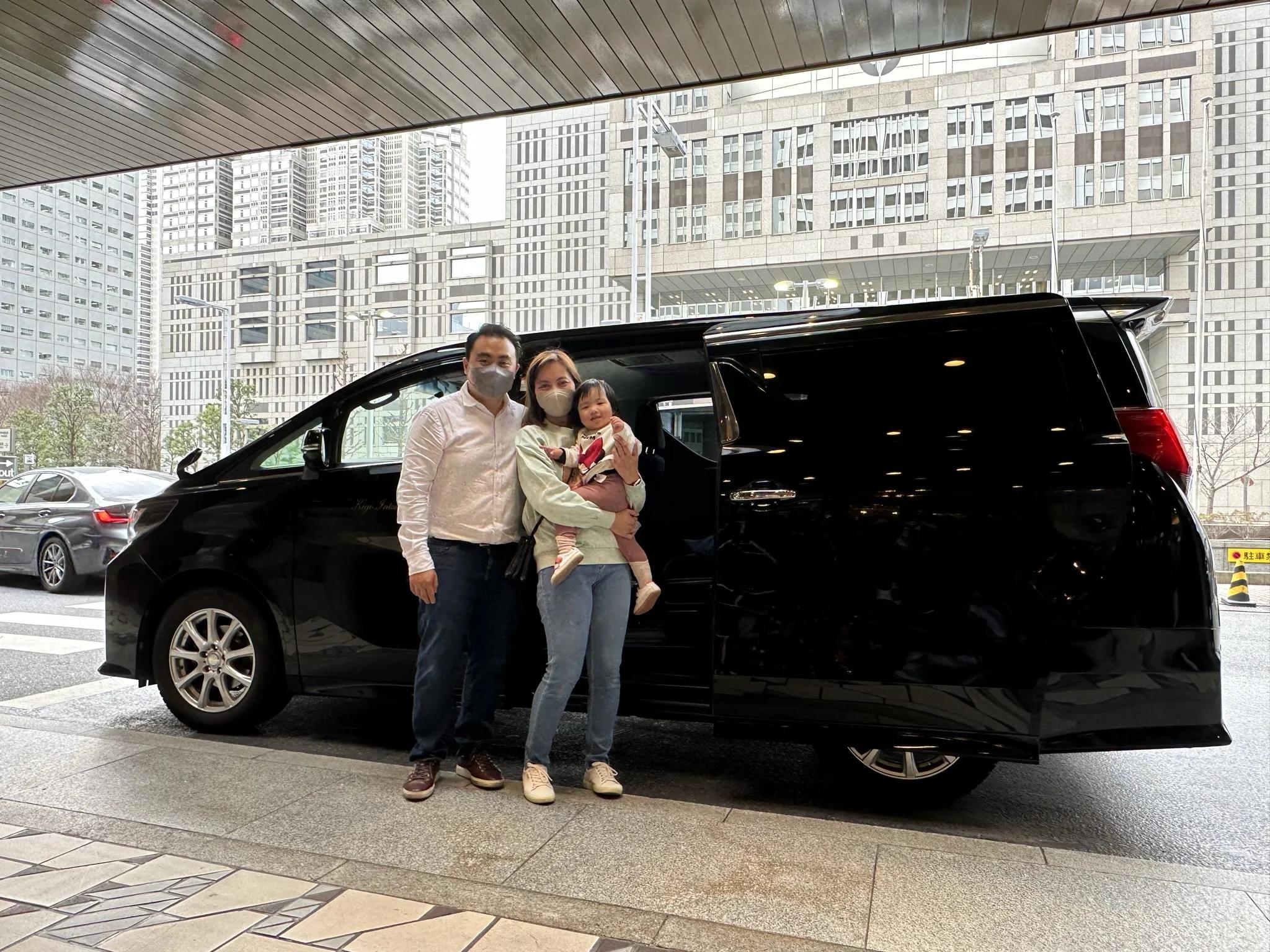 family in front of private vehicle in japan