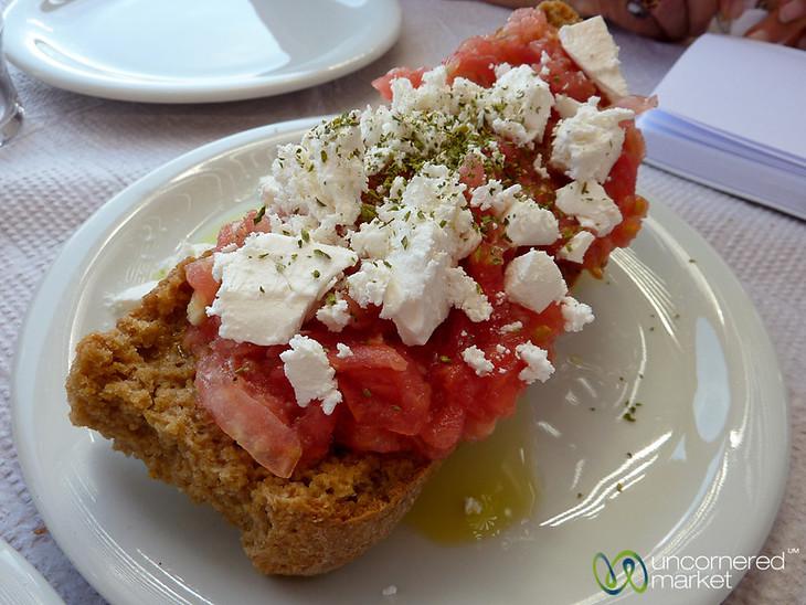 A delicious slice of dakos (dried bread topped with tomatoes, cheese and olive oil) at Seli Ambelou Tavern near Venetian windmills on Crete, Greece.