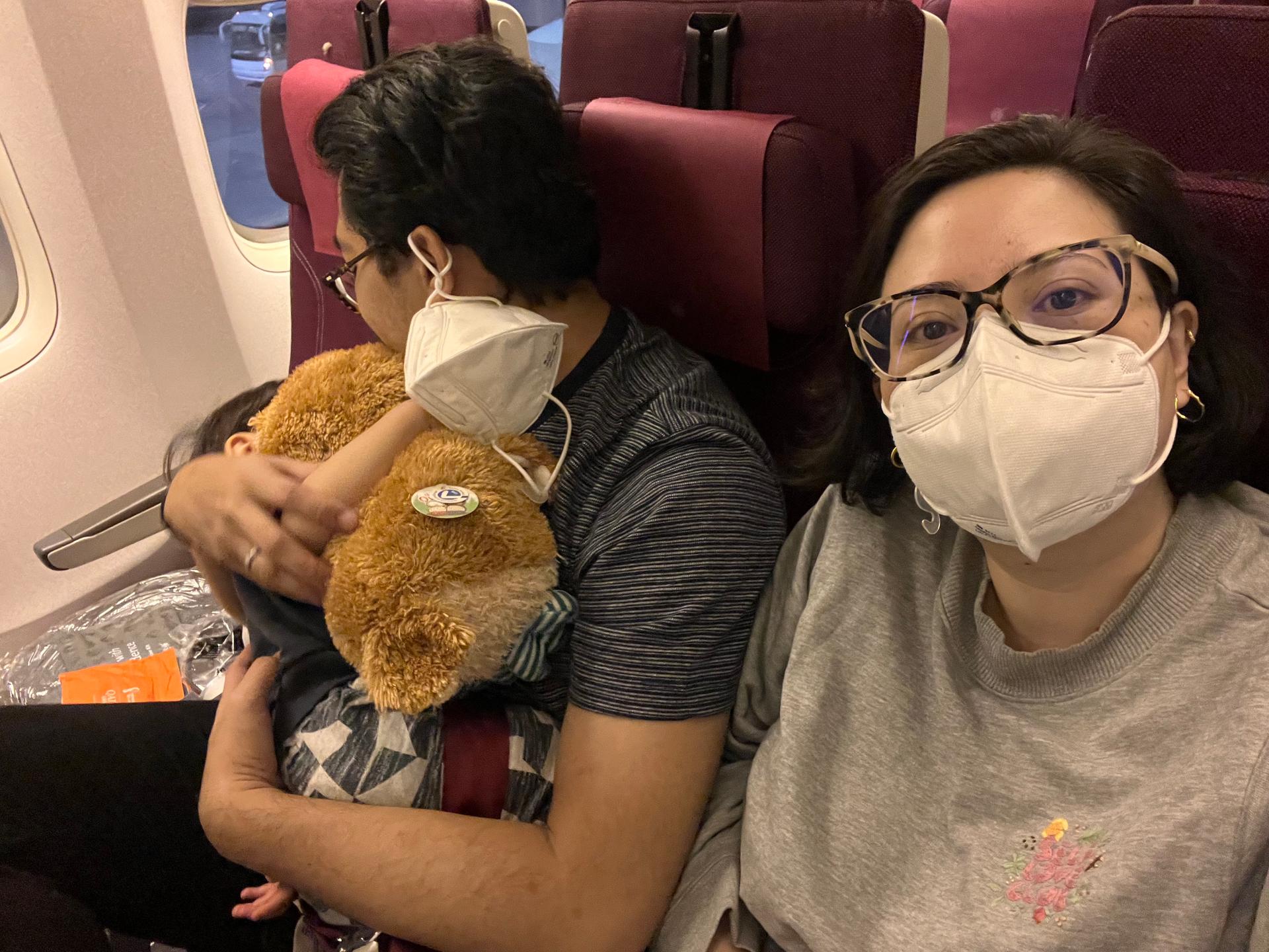 A family with sleeping toddler on an airplane